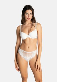Ensemble de lingerie blanc comprenant un soutien-gorge rembourré en tissu lisse avec des accents de dentelle, assorti à une culotte en dentelle semi-transparente à motifs floraux.