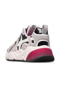 Sneaker grigio e nero con una suola in gomma spessa e testurizzata. Presenta un logo a stella bianca, dettagli in suede e un tallone con gradiente rosa.