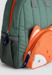 Rucsac verde matlasat cu un design cu o vulpe portocalie, având un buzunar frontal cu fermoar, un buzunar lateral din plasă și fermoare portocalii contrastante.