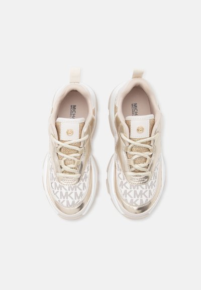 Ζευγάρι μπεζ και λευκά sneakers Michael Kors με χρυσές λεπτομέρειες και μοτίβο λογότυπου MK σε λευκό φόντο.