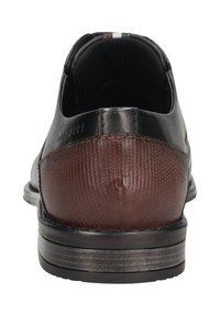 Schwarzer Lederschuh mit einem braunen strukturierten Absatz, glatter Oberfläche und einem dezenten Logo-Detail. Merkmale ein elegantes Design und eine geschichtete Sohle.
