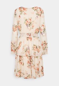 Robe fleurie avec des manches longues, en tissu crème, taille smockée, jupe superposée, et motifs de fleurs colorées dans des teintes de rose, violet et vert.