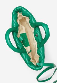 Groene leren tas met een gequiltde textuur, twee korte handvaten, een verwijderbare schouderband en een interieur dat is gevoerd met beige stof.