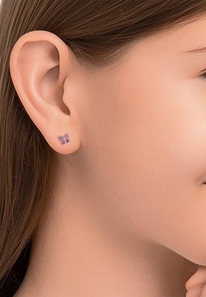 Silberne Schmetterling-Ohrringe mit pinken und lila Edelsteinen, glänzendes Finish und zartes Flügeldesign. Am Ohr eines Models getragen.