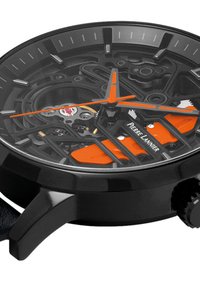 L'orologio nero presenta un quadrante scheletrato con dettagli e indicatori arancioni. La parte metallica mette in evidenza i dettagli del movimento. Cassa rotonda con finitura texturizzata.