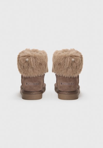 Botas de tobillo de ante marrón con un suave puño de piel sintética, suela de goma plana y costuras decorativas. Con un pequeño logo en la parte trasera.