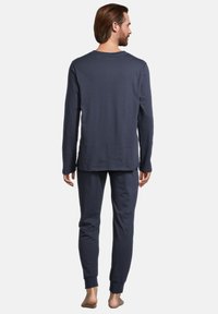 Ensemble de pyjama à manches longues navy en coton doux ; comprend un haut à col rond et un pantalon fuselé avec des poignets en côtes.