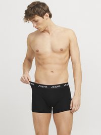 Schwarze Boxershorts mit einem elastischen Bund, der weiße Markenlogos trägt. Der Stoff ist glatt, mit tailliertem Schnitt und kurzen Beinen sowie gesteppten Details.
