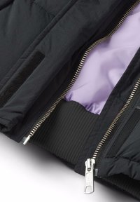 Svart vadderad jacka med dragkedja, med lila foder, ribbade muddar och en kardborreaccent på ytterlagret.