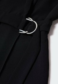 Black fabric with pleats and a silver circular hardware detail on the side. Smooth texture and fitted design.