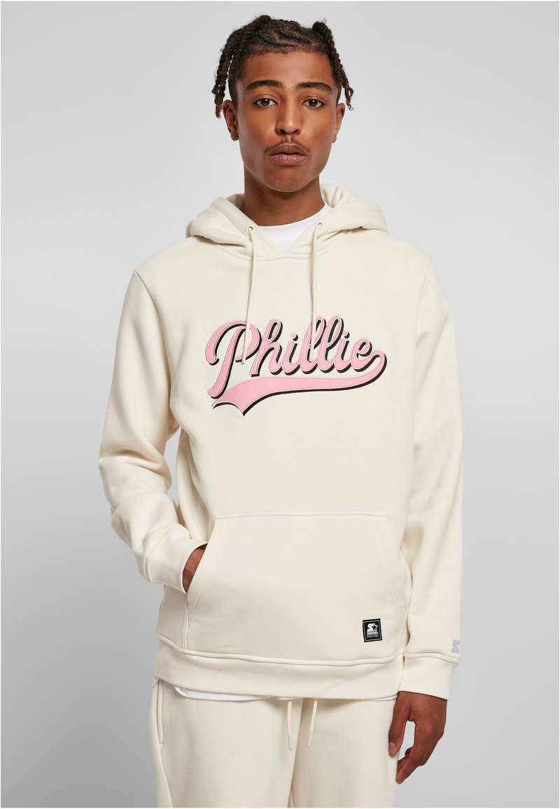 Kremfarget hettegenser med snor, stort rosa skriftnavn "Phillie" logo, frontlomme og en svart merketagg nederst. Myk tekstur, standard passform.