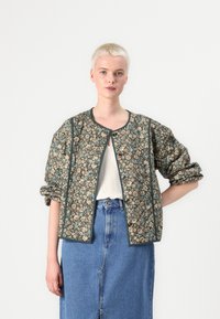 Gequiltede jas met een bloemenpatroon in bruin, blauw en crème, met een ronde halslijn, knoopsluiting en volumineuze mouwen.