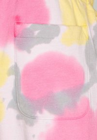 Katoenen stof met een tie-dye patroon met roze, gele en grijze vlekken. Inclusief een zak met gestikte rand.