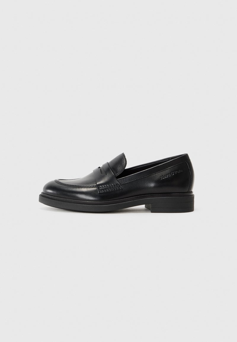 Mocassin penny en cuir noir avec talon bas, bout arrondi et couture discrète sur un fond gris clair uni.
