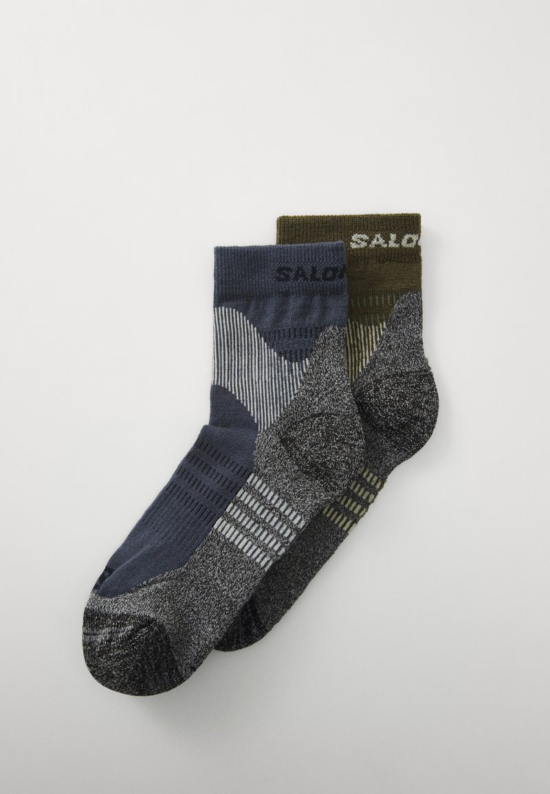 Dve pari nogavic: en par v temno modri barvi s črtastim vzorcem in drugi par v olivno zeleni barvi z teksturiranim dizajnom. Obe imata oblazinjen podplat.