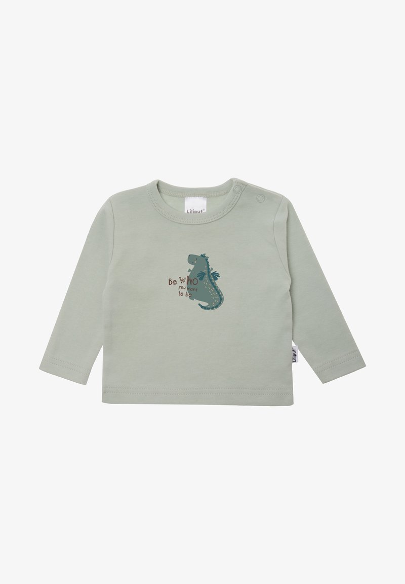 Long-sleeve green cotton shirt featuring a dinosaur graphic with the text "Be who you want to be" in brown. Snap closure at the shoulder.
