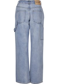 Jean bleu clair à jambes larges vu de dos, deux grandes poches arrière, passants de ceinture, détail de sangle latérale, étiquette beige à la taille.