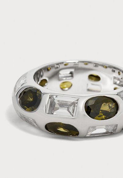 Bague en argent avec des grandes pierres précieuses alternant rectangles transparents et ovales foncées, serties dans un anneau poli sur fond blanc.