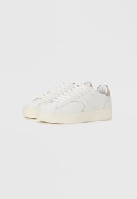 Sneakers bianchi con una tomaia in pelle liscia, punta rotonda e design minimalista. Presentano accenti grigi sottili e una suola testurizzata di colore bianco sporco.