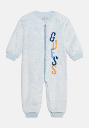 Grenouillère en polaire bleu clair pour bébé avec fermeture éclair devant et lettres "GUESS" multicolores brodées verticalement sur la poitrine.