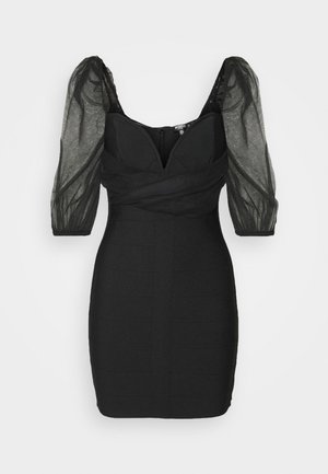 Czarna dopasowana mini sukienka z przejrzystymi, bufkowymi rękawami o długości do łokcia i dekoltem w kształcie serca.