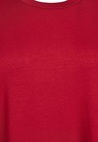 Červené bavlnené tričko s hladkou textúrou, okrúhlym výstrihom a krátkymi rukávmi. Látka má jemný lesk a minimálne švy.