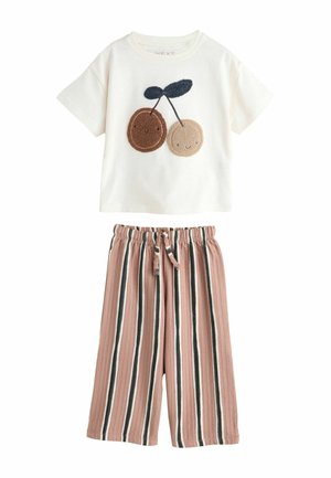 Short-sleeved cream T-shirt featuring two plush cherry appliqués. Paired with striped blush and brown shorts with an elastic waistband.