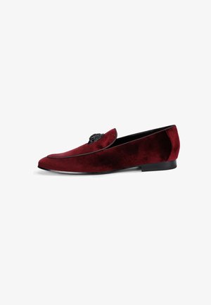 Mocassino in velluto rosso dal design elegante, con un accento floreale nero decorativo sulla tomaia e una suola piatta nera.