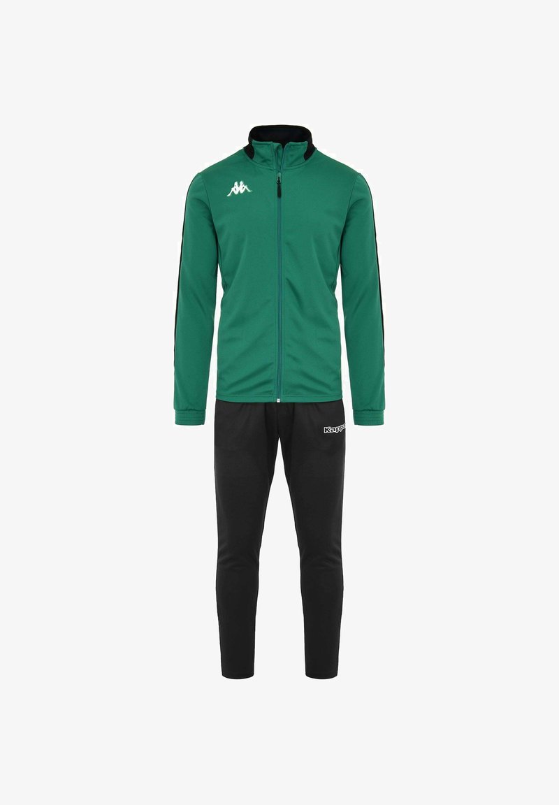 Giacca verde con zip e collare nero, dettagli neri sulle maniche; abbinata a pantaloni neri a sigaretta. Presenta il logo Kappa su entrambi i capi.