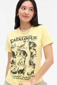 Yellow cotton t-shirt featuring black cat illustrations and text in a bold font. Short sleeves, round neckline, and casual fit.