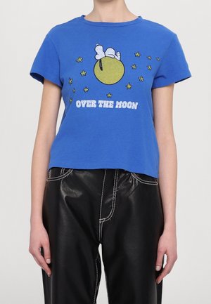 Blå kortærmet skjorte med Snoopy, der ligger på en gul måne, omgivet af stjerner, med teksten "OVER THE MOON" i hvide bogstaver.
