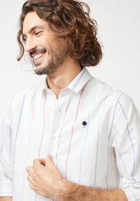 Witte button-up shirt met pastelkleurige verticale strepen, voorzien van een kleine marineblauwe boom borduursel en een klassieke kraagontwerp.