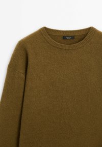 Pull vert olive doux à col rond avec col et poignets côtelés, en mélange de laine, présenté à plat sur fond blanc.