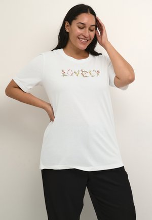 Hvid kortærmet t-shirt lavet af blødt stof med blomstermønster broderet med ordet "KÆRLIGHED" i multicolore tråd tværs over forsiden.