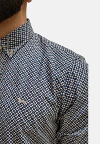 Camicia a button-up a fantasia blu e bianca, caratterizzata da un motivo a griglia con accenti sottili e un piccolo logo ricamato sul petto.