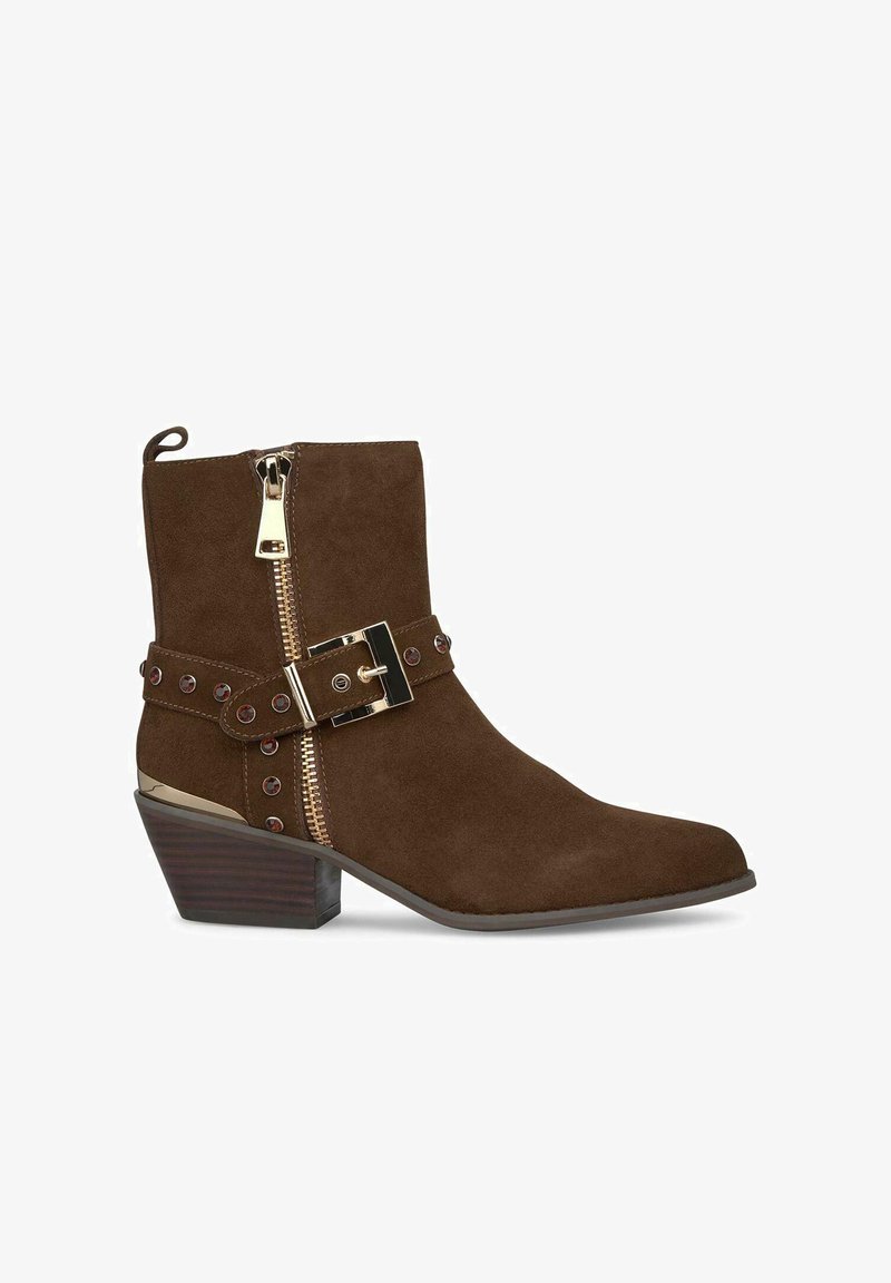 Bruine suède enkelboot met een spitse neus, gouden rits en decoratieve gesp. Heeft een gestapelde hak en studs als accenten.
