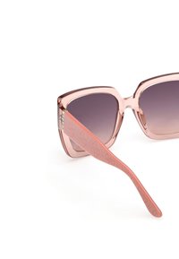 Lunettes de soleil carrées avec une monture rose translucide, des verres dégradés et des branches roses avec logo embossé. Finition lisse et design moderne.