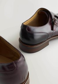 Bruine leren schoenen met een gladde afwerking en ronde neus, voorzien van een gespdetail en een gestapeld houten hak. Lichtbruine binnenvoering.
