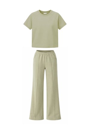 Lichtgroen cropped T-shirt met korte mouwen gecombineerd met wijde broek met hoge taille, voorzien van een elastische tailleband en voornaad.