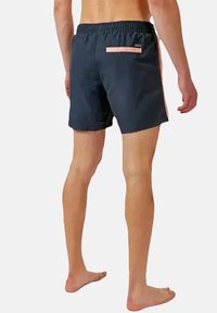 Shorts de bain bleu foncé avec une taille élastique, présentant une poche d'accent rose clair à l'arrière et une texture lisse.