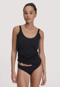 Zwarte tanktop met gegolfde kantafwerking en bijpassende zwarte bikini-stijl onderbroek, beide van zacht, aansluitend materiaal.