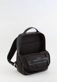 Mochila negra con un acabado de cuero suave y tela texturizada. Cuenta con un asa en la parte superior, un bolsillo frontal con cremallera y compartimentos interiores.