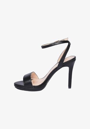 Sandalo nero con tacco alto a spillo sottile, cinturino alla caviglia e punta aperta su sfondo bianco.