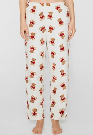 Pantalon de pyjama en polaire avec un fond crème orné de motifs répétés d'oursons portant chacun une chemise rouge ; coupe droite.