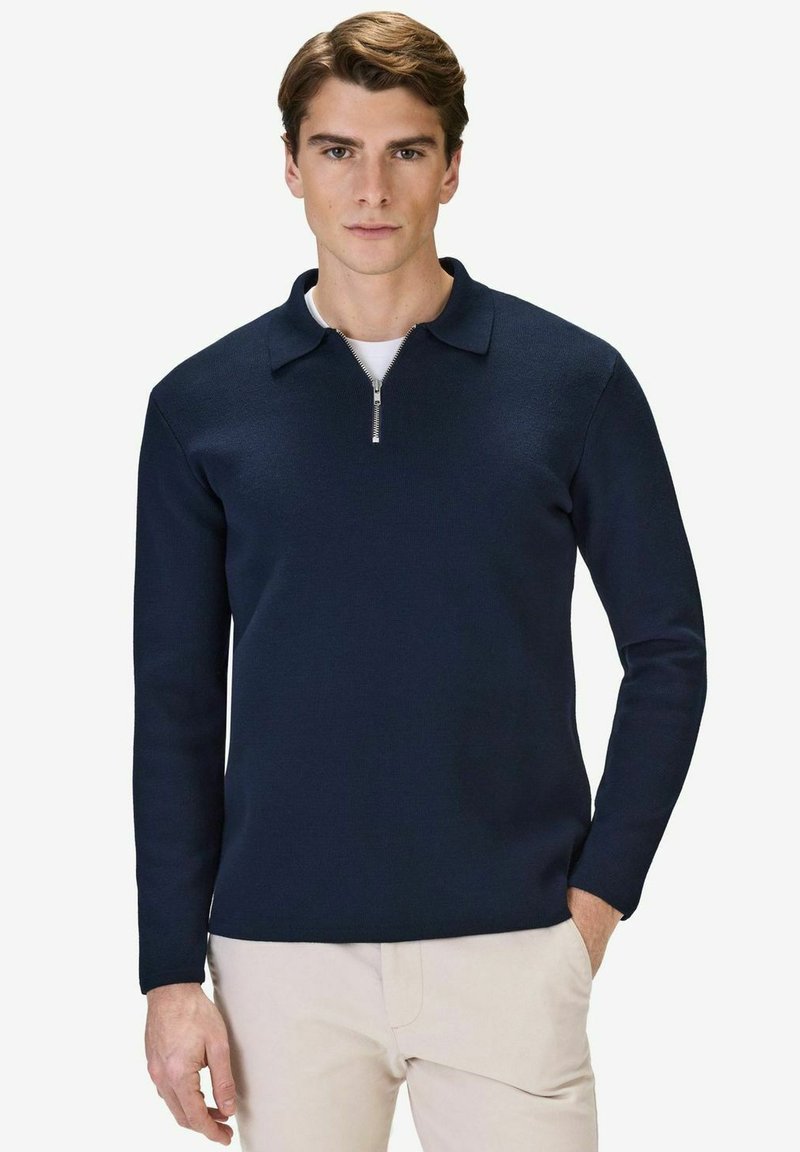 Marinblå zip-neck pullover gjord av stickat tyg, med krage, långa ärmar och en silverdragkedja vid halsen.