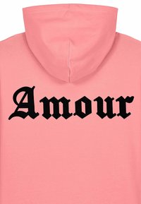 Haut à capuche rose avec un imprimé gothique noir "Amour" dans le dos. Il possède une capuche standard et un tissu doux et texturé pour le confort.