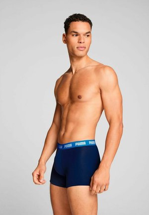 Navy boxer briefs made of stretchy fabric, featuring a blue Puma logo waistband; fitted design with a smooth texture and contoured shape.