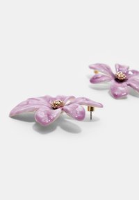 Fialové smaltované náušnice v tvare kvetu so zlatými akcentmi, päťlístkovým dizajnom a textúrovaným stredom. Zapínanie na puzetu pre bezpečné nosenie.