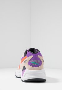 Reebok-sneakers med en beige, lila och orange färgsättning. Har material av mocka och nät, framträdande logotyp och en dämpad sula.