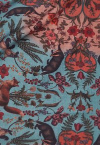 Tejido estampado que presenta ilustraciones coloridas de zorros y tejones entre flores y follaje sobre un fondo azul claro.